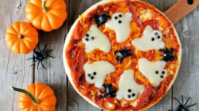 a cheese and tomato pizza with cheese ghosts on the toppings