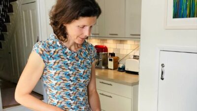 Jo Sardella chopping vegetables standing in her kitchen