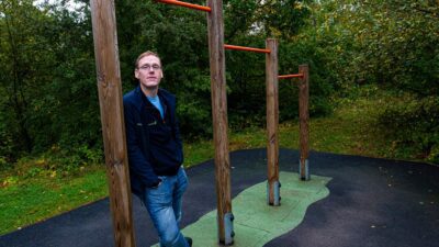 David Breaker leaning on outdoor pull up bars