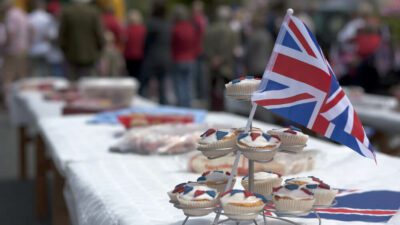 A side view of a table with a tiered display of cupcakes with a union flag on the top