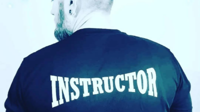 A man with his back to the camera with the word Instructor on the back