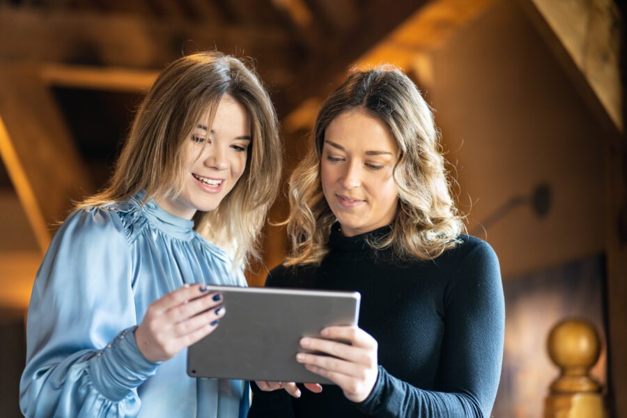 Two women holing a tablet smiling at the screen