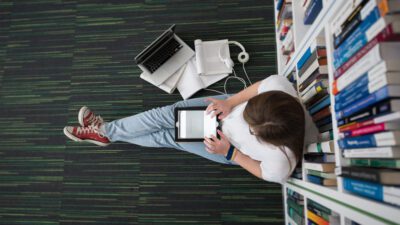 girl sitting next to books, learning and working