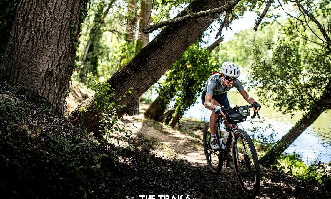 A woman riding a bike fast through a forest