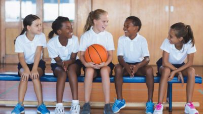 Children sitting, smiling with a ball